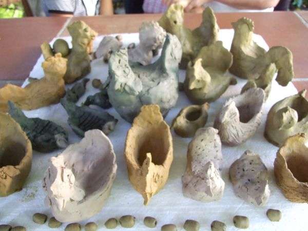 Mladi prsti v glini v hladu umetničinega doma